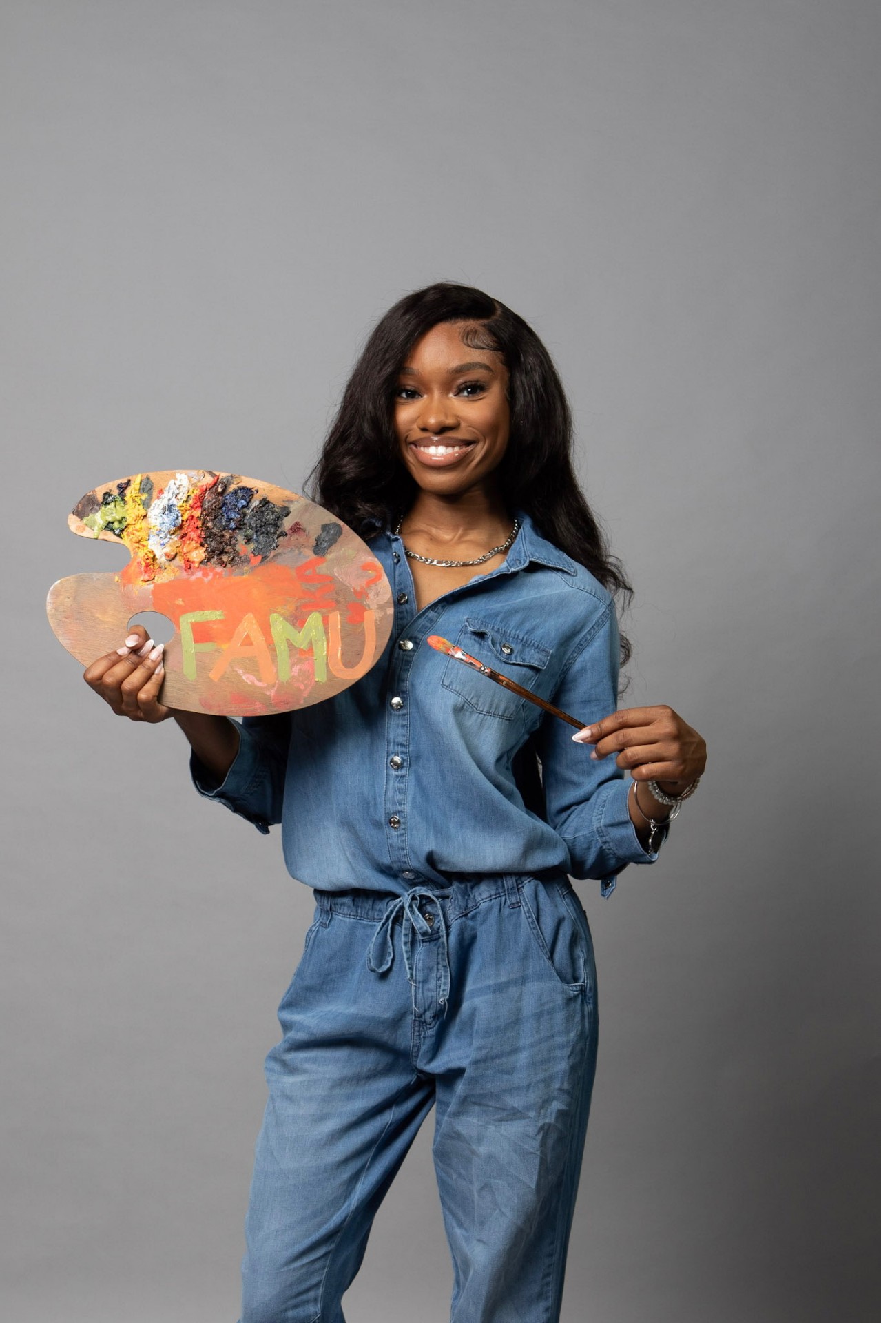 Carlynn — Florida A&M graduate holding her FAMU-lettered oil palette and paintbrush